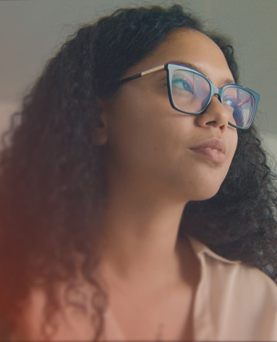 A woman with glasses looking out of frame.